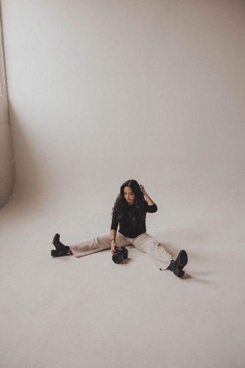 A playful seated pose on the white backdrop