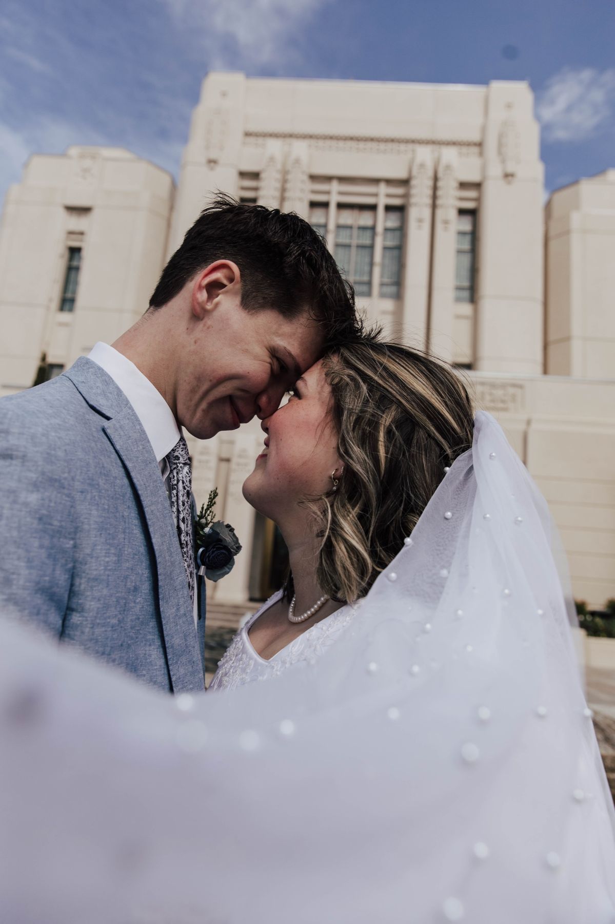Bride and groom forehead to forehead outside the temple
